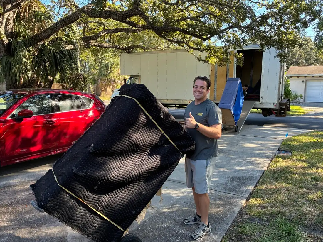 Panther Moving crew member loading wrapped furniture onto the truck